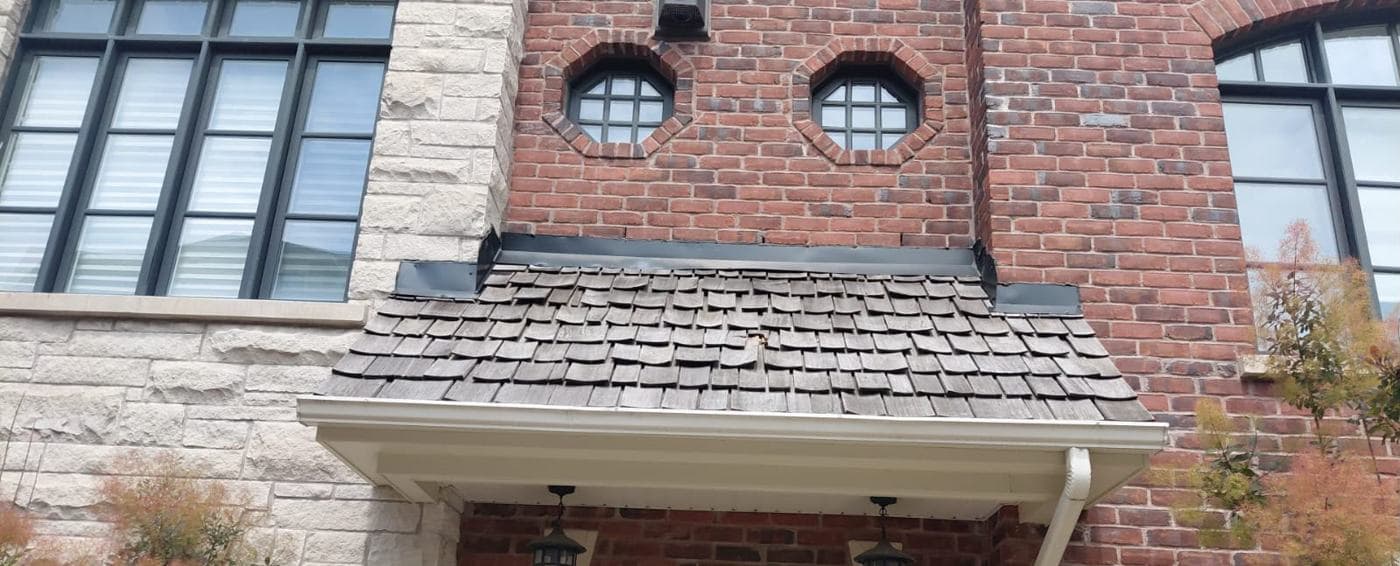 Finished cedar shake canopy roof over an entrance