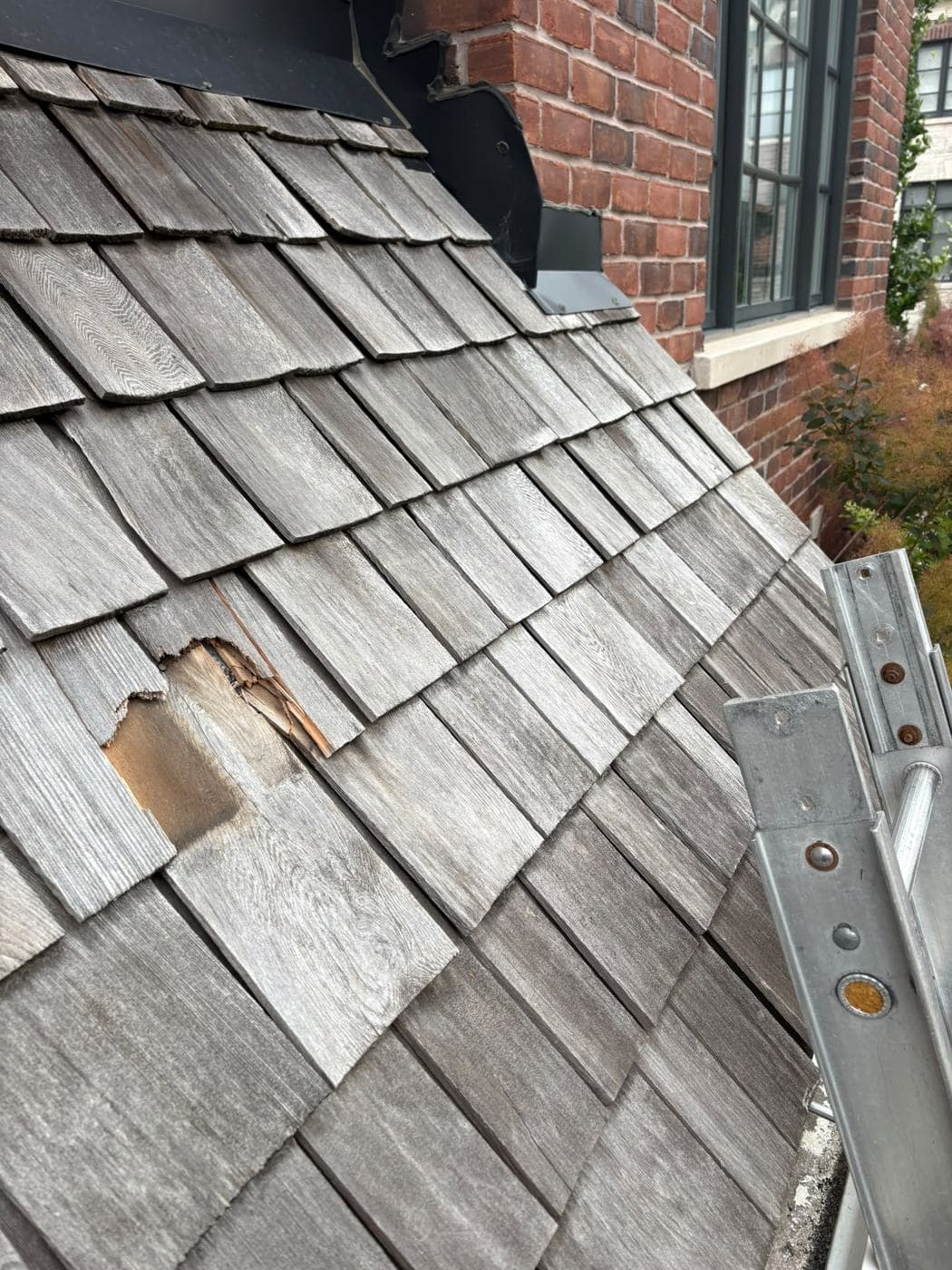 Weathered, damaged cedar shake roof before replacement