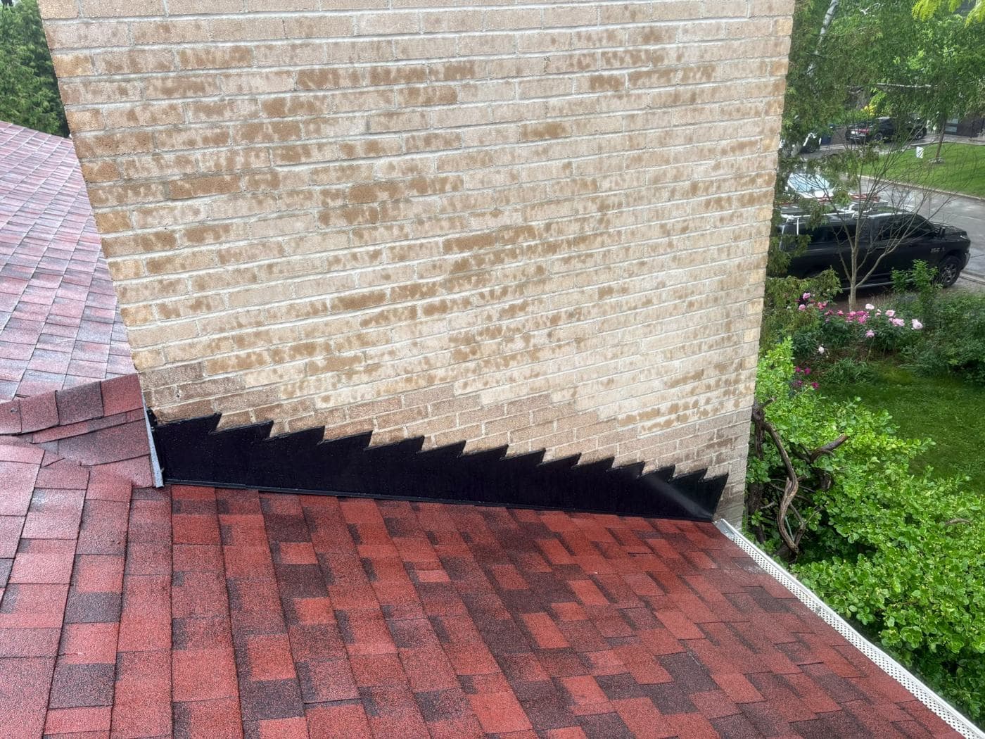 Chimney flashing detail on a red shingle roof