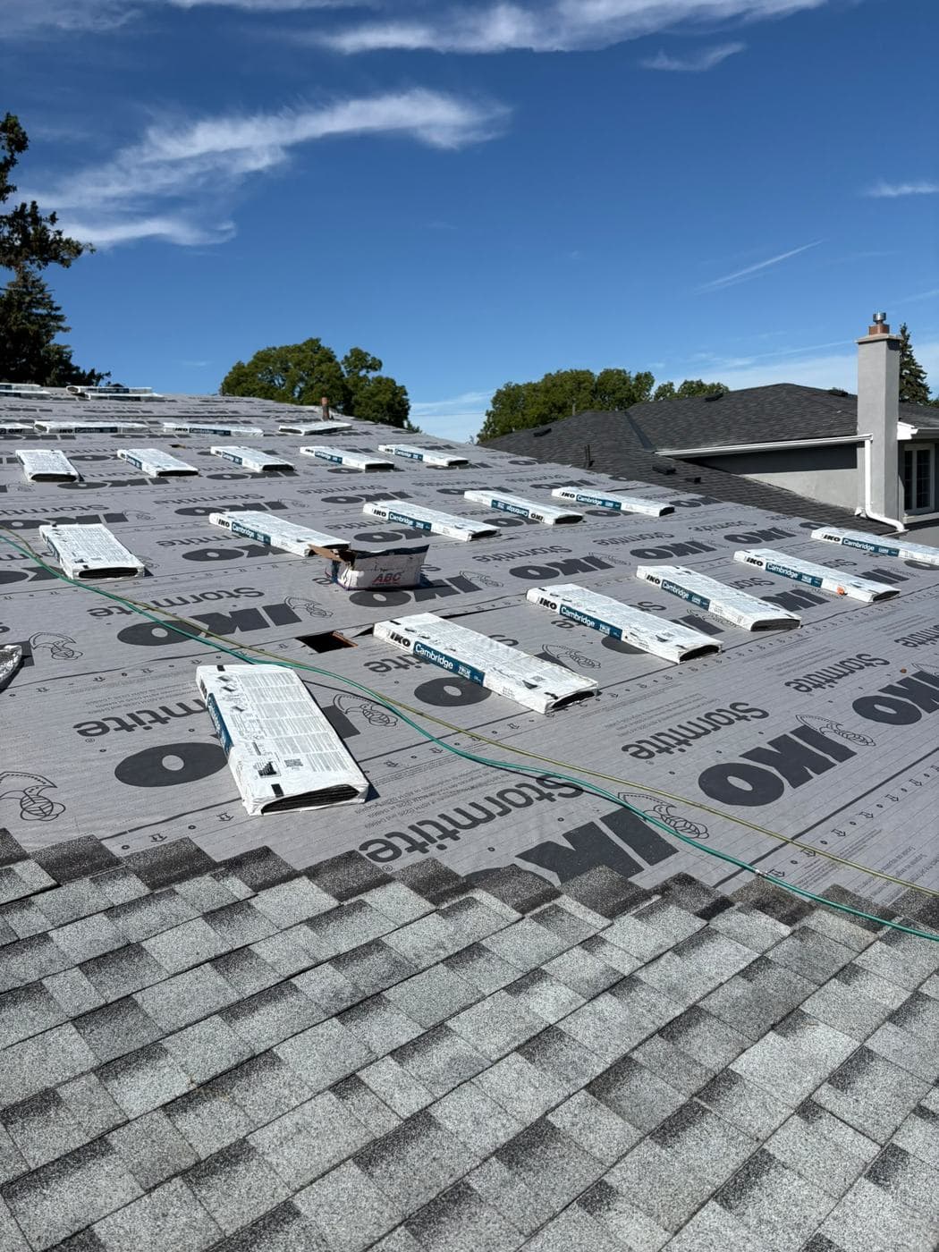 IKO Cambridge shingle bundles staged on synthetic underlayment